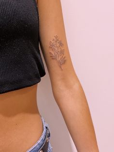 a woman with a flower tattoo on her left arm and right arm behind her back