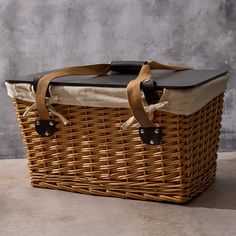 a wicker picnic basket with leather handles