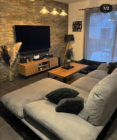 a living room filled with furniture and a flat screen tv on top of a wall