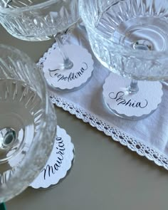 there are four glass dishes with name tags on them