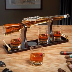 After a day of shooting clays, you’ll love coming home to this awesome shotgun whiskey decanter set! Designed to look like a genuine 12 gauge shotgun, this impressive decanter comes with a handsome wooden stand, four glasses, a stopper, and a funnel. The decanter set will look badass on display in your living room on your mantle or as the centerpiece for your home bar. You can offer a drink to all of your guests using this shotgun decanter and the unique rocks glasses, which they’ll all be amaze Decanter Display, Whiskey Lounge, Novelty Gifts For Men, Personalized Whiskey Decanter, Home Wet Bar, Bourbon Gifts, Unique Glasses, Whiskey Decanter Set, Personalized Whiskey