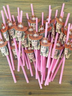 there are many pink toothpicks with pictures on them that look like people's heads