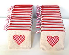 several red and white towels with hearts on them sitting next to each other in front of a white wall