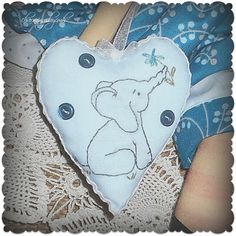 a heart shaped pillow with an image of a koala bear on it's side