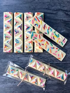 four pieces of white chocolate with sprinkles on them next to each other