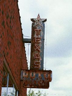 an old neon sign on the side of a brick building that says tex's pub and bakery