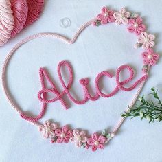 a crocheted heart with the word alice written in cursive letters on it