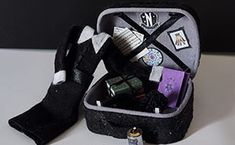 an open suitcase sitting on top of a table next to a pair of black gloves