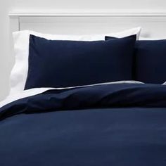 a bed with blue sheets and white pillows