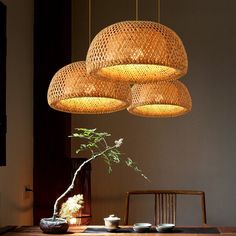 a bamboo chandelier hanging over a wooden table with bowls and cups on it