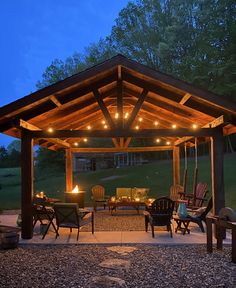 a covered patio area with chairs and lights on the ceiling is lit up at night