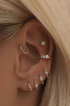 a woman with blonde hair wearing three different ear piercings