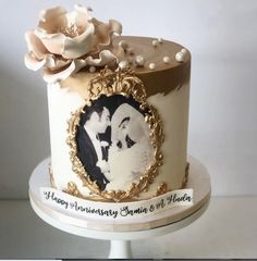 a wedding cake decorated with an image of two people and flowers on top is sitting on a table