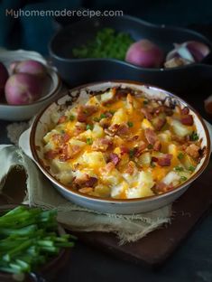 a casserole dish with potatoes, bacon and cheese