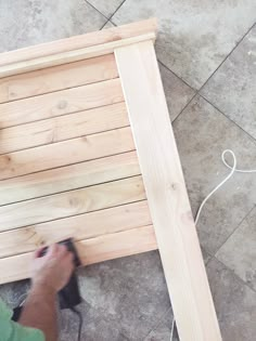 a person sanding up some wood on the ground