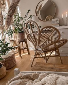 a living room filled with lots of furniture next to a mirror and potted plants