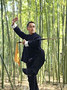 the man is practicing his martial skills in the bamboo forest