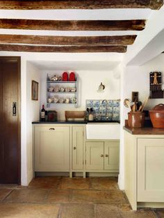 an instagram photo of a kitchen with white cabinets and wood beams on the ceiling