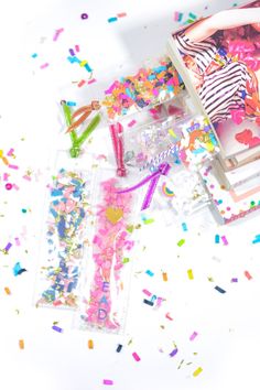 confetti and streamers are scattered around a woman in a striped dress sitting on a chair