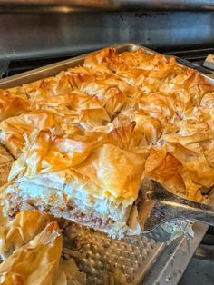 a pie sitting on top of a metal pan next to a spatula filled with food