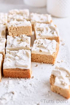 several pieces of cake sitting on top of a white counter next to a cup and saucer