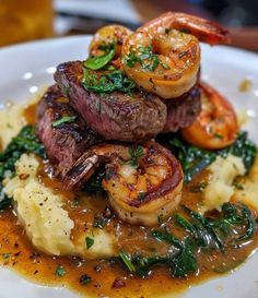 steak, shrimp and grits on top of mashed potatoes with gravy