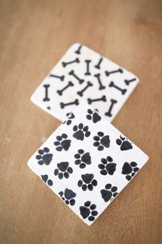 two dog paws and bones coasters sitting on a table with one paw print in the middle