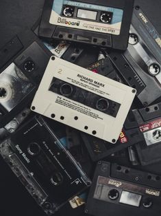 an assortment of audio tapes and cassettes are piled on top of each other,