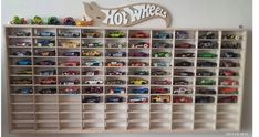 toy cars are lined up on shelves in a playroom with the word hot wheels above them