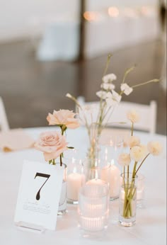 the table is set with candles and flowers in glass vases, which are labeled 7