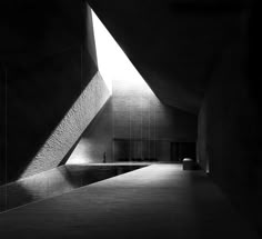 a black and white photo of the inside of a building with light coming through it