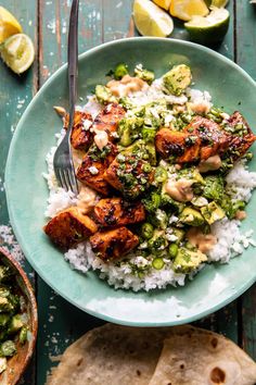 a blue plate topped with chicken and broccoli covered in sauce next to pita bread