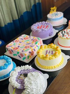 a table topped with lots of cakes covered in frosting