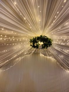 the ceiling is covered with white drapes and lights