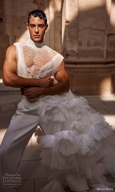 a man dressed in white posing for a photo