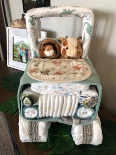 two stuffed animals sitting on top of a chair made out of diapers and blankets