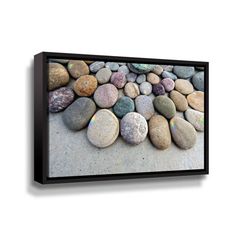 a group of rocks sitting on top of a cement ground next to a white wall