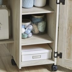 an open cabinet filled with jars and yarn