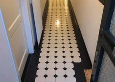 an empty hallway with black and white tiles