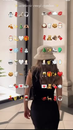 a woman in a black dress and hat walking down a hallway with lots of stickers on her face