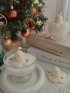 two candles sitting on top of plates next to a christmas tree