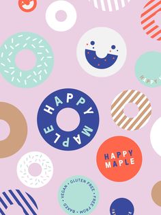 colorful donuts are arranged on a pink background with the words happy day written in large letters