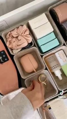 a woman is holding an open case with various items in it and she has her hand on the lid