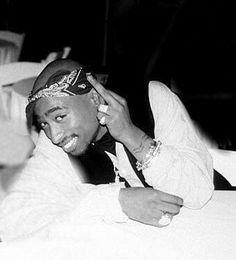 a black and white photo of a man sitting at a table talking on the phone