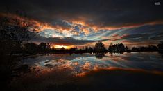 the sky is reflected in the water at sunset