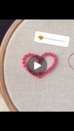 a close up of a piece of cloth with two hearts on it and some crochet