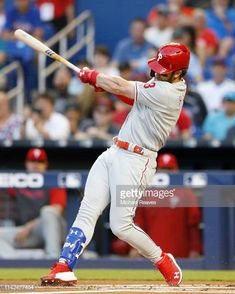 a baseball player swinging a bat at a ball in front of a crowd on the field