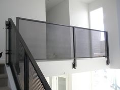 a black cat sitting on top of a stair case next to a window in a house