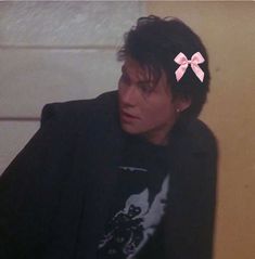 a man with a pink bow in his hair