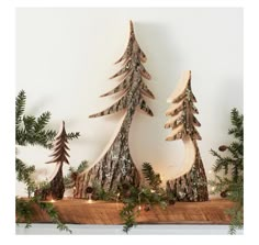 three wooden christmas trees sitting on top of a mantle